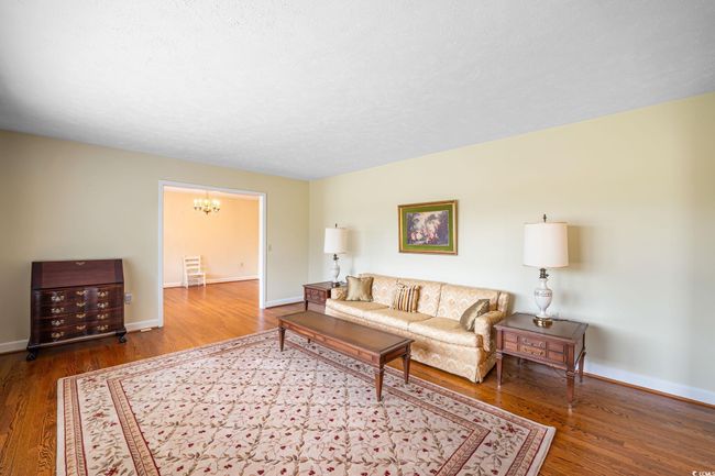 Living area with a chandelier, wood finished floors, and baseboards | Image 30