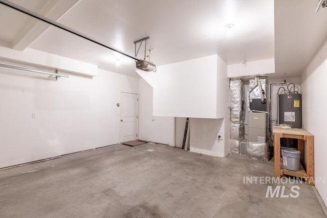Garage with electric water heater, heating unit, and a garage door opener | Image 25