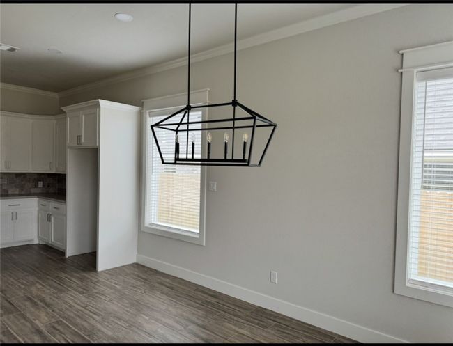 Unfurnished dining area featuring dark wood-type flooring and ornamental molding | Image 17