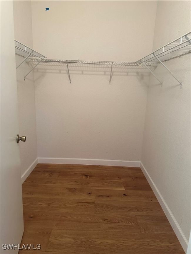 Walk in closet with dark wood-type flooring | Image 12