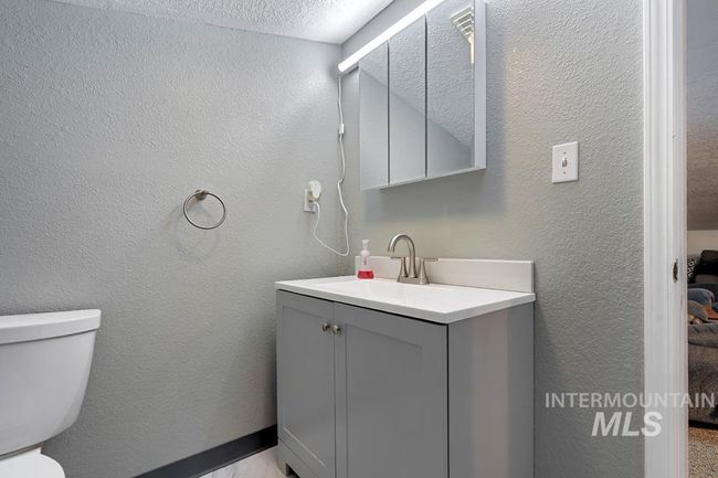 Bathroom featuring vanity and a textured wall | Image 26