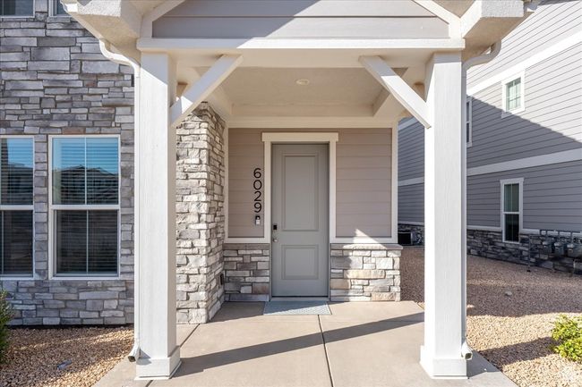 View of exterior entry featuring stone siding and covered porch | Image 4