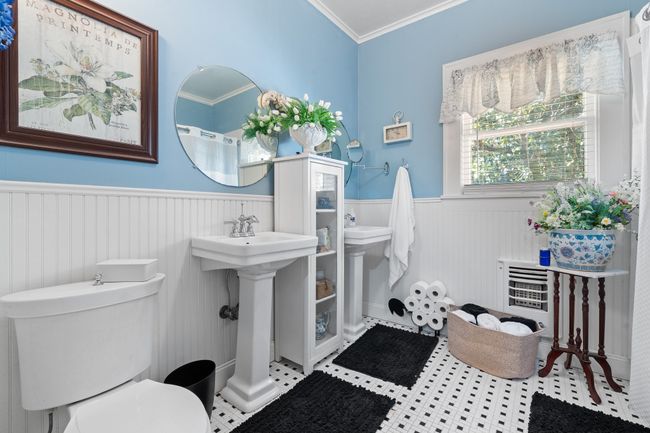 Bathroom with toilet, wainscoting, crown molding, and a sink | Image 23
