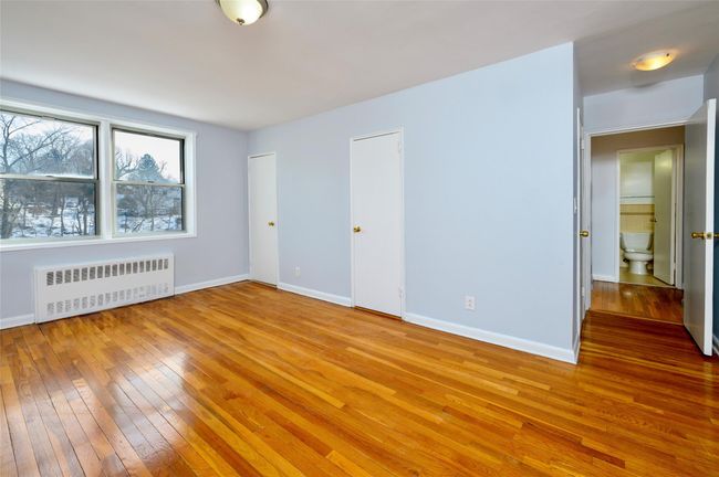 Spare room featuring radiator heating unit and light wood-type flooring | Image 12