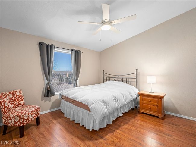 Bedroom with baseboards, a ceiling fan, and light wood finished floors | Image 42