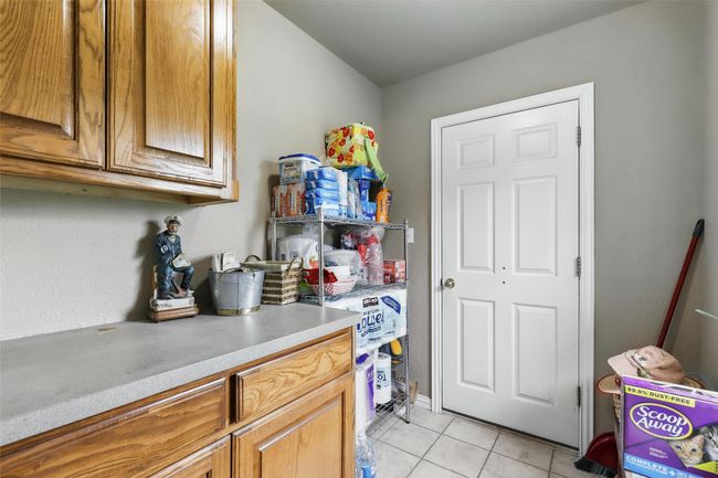 Kitchen featuring light countertops, light tile patterned flooring, and brown cabinets | Image 22