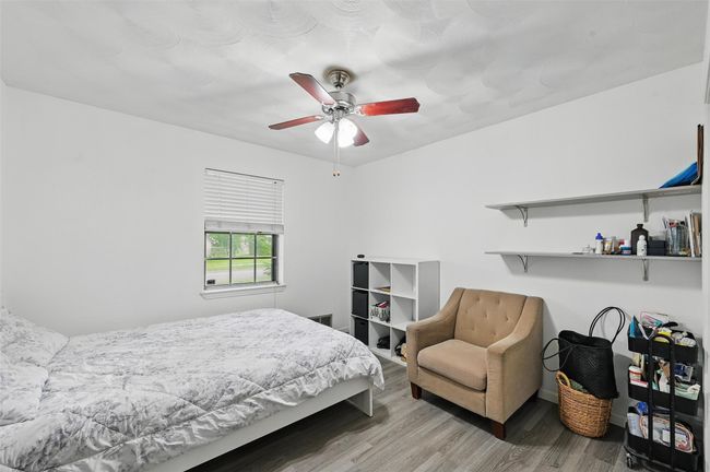 Bedroom featuring wood finished floors, ceiling fan, and baseboards | Image 19