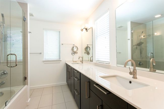 Full bathroom with tile patterned flooring, double vanity, and shower / bath combination with glass door | Image 24