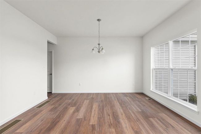 Empty room with a notable chandelier and dark hardwood / wood-style floors | Image 28