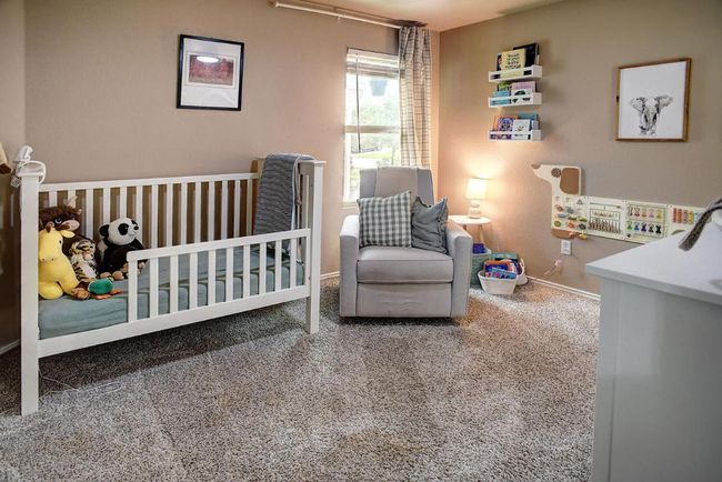 Carpeted bedroom featuring baseboards and a nursery area | Image 22