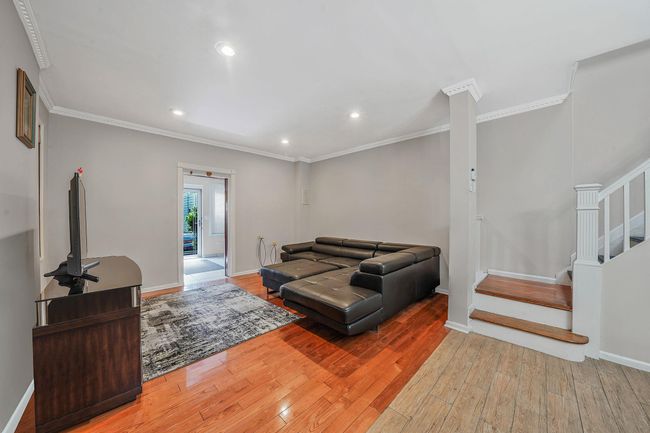 Living area with ornamental molding, wood-type flooring, stairway, baseboards, and recessed lighting | Image 7