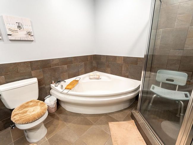 Bathroom featuring tile patterned floors, a stall shower, tile walls, and a bath | Image 26