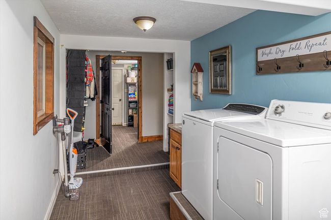 Laundry area with cabinets, a textured ceiling, and washer and clothes dryer | Image 31
