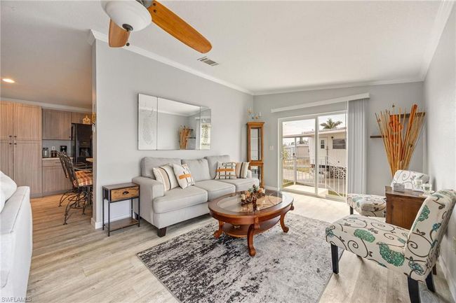 Living area featuring ornamental molding, visible vents, ceiling fan, and light wood finished floors | Image 18