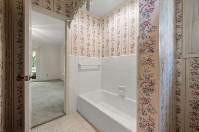 Bathroom featuring tile patterned floors, a bath, wainscoting, and crown molding | Image 30
