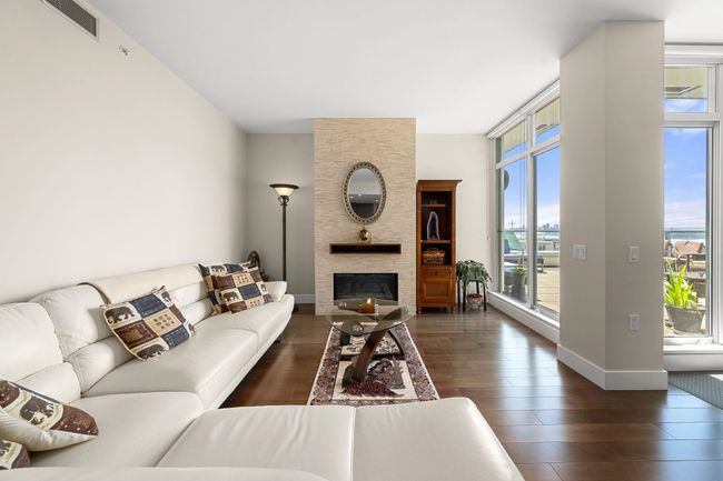 Living area with wood finished floors and a fireplace | Image 5