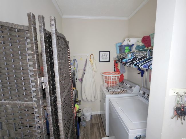 Washroom featuring washing machine and dryer, hardwood / wood-style floors, and ornamental molding | Image 12