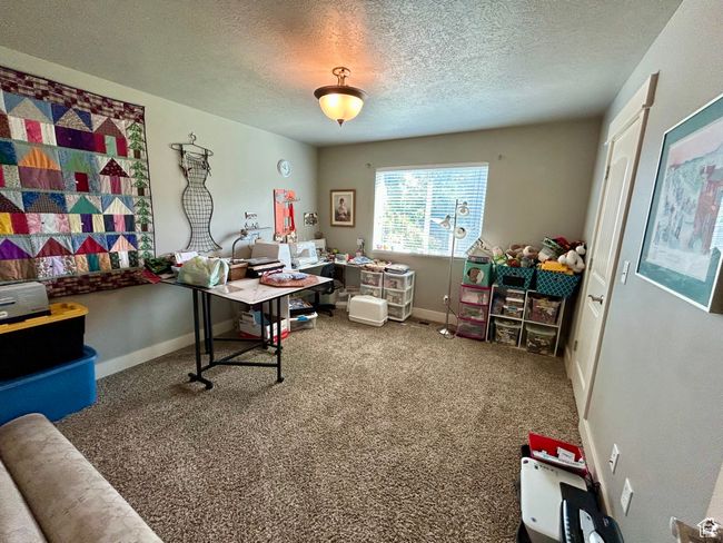 Carpeted home office with a textured ceiling and baseboards | Image 17