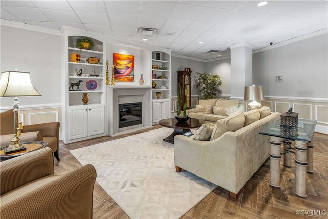 Living room with visible vents, ornamental molding, a decorative wall, built in features, and wainscoting | Image 23