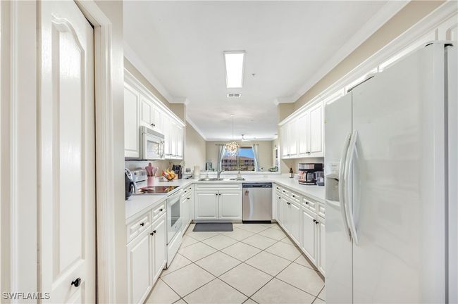 Kitchen with kitchen peninsula, sink, crown molding, white cabinets, and white appliances | Image 6