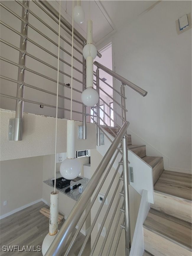 Staircase featuring baseboards and wood look vinyl floors | Image 15