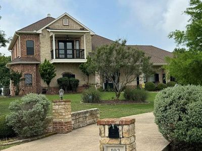 View of front facade featuring a front yard and a balcony | Image 1