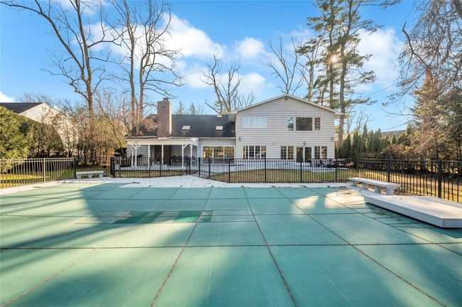 View of swimming pool with a diving board and a patio | Image 21