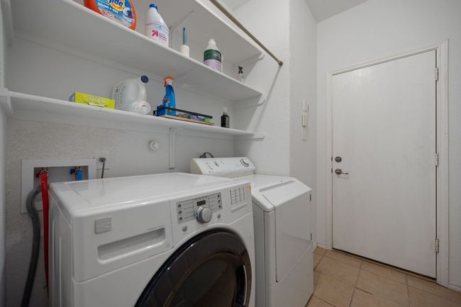 Laundry room with washer and clothes dryer and light tile patterned flooring | Image 26