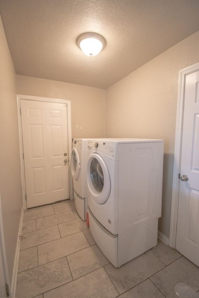 Washroom with separate washer and dryer, a textured ceiling, baseboards, and light tile patterned flooring | Image 16