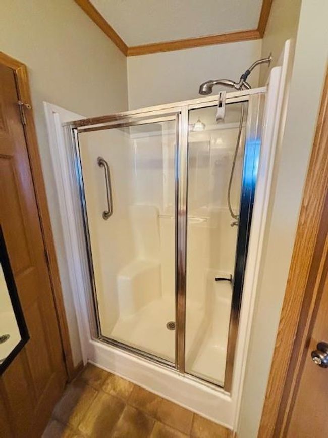 Bathroom with crown molding and a stall shower | Image 16