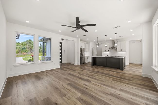 Unfurnished living room featuring a sink, ceiling fan, wood finished floors, recessed lighting, and baseboards | Image 7