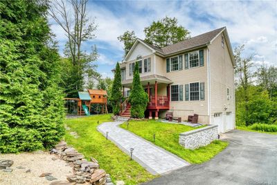 View of front of home featuring a garage, a front lawn, and a playground | Image 1