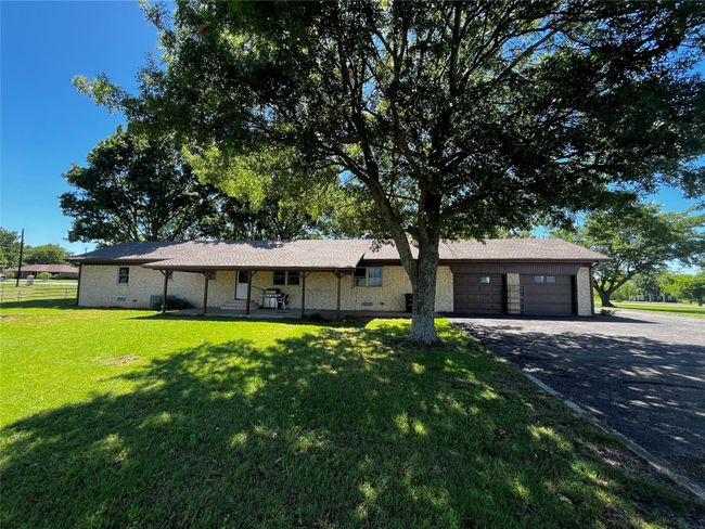 A dreamy back yard, complete with well maintained grass, majestic trees, and an oversized patio! Spacious two-car garage. | Image 4
