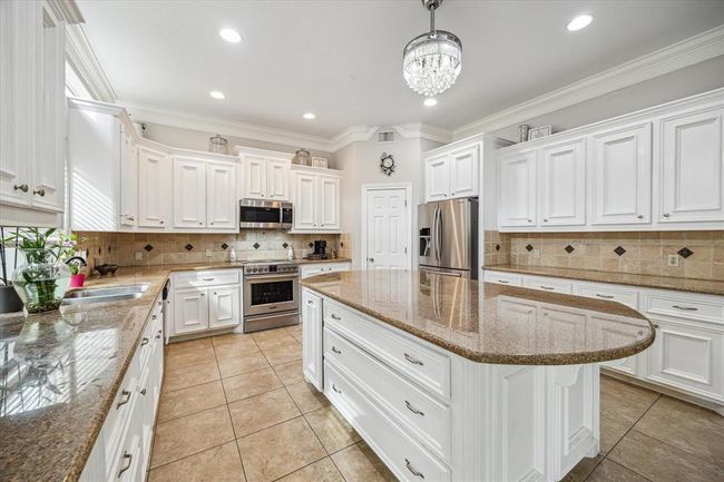 Gourmet kitchen with high end SS appliances and granite countertops. Fridge conveys with the sale. | Image 11