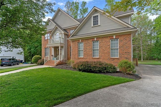 Traditional-style home featuring brick siding, a shingled roof, a front yard, and concrete driveway | Image 48
