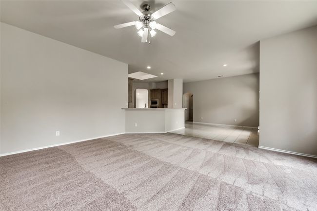 Unfurnished living room with light carpet, ceiling fan, recessed lighting, and arched walkways | Image 20
