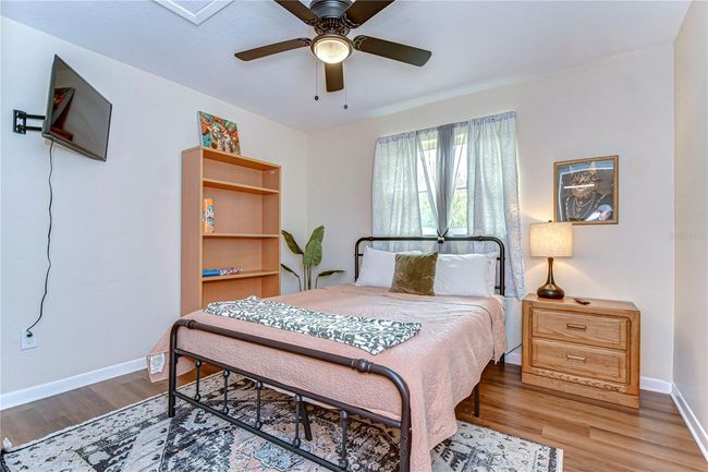 The guest bedroom features a queen size bed and a 32" smart tv | Image 5