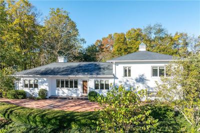 Stately exterior with a huge, stamped concrete terrace for entertaining or just relaxing amid your woodland escape. | Image 1