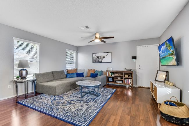 Living room with ceiling fan and wood finished floors | Image 4
