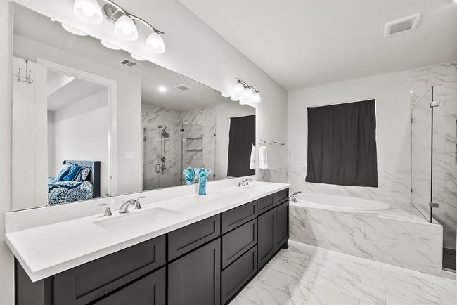 Sleek primary bathroom with dual vanities. | Image 16