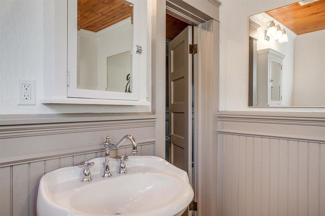 Bathroom featuring wood ceiling, a sink, and crown molding | Image 32