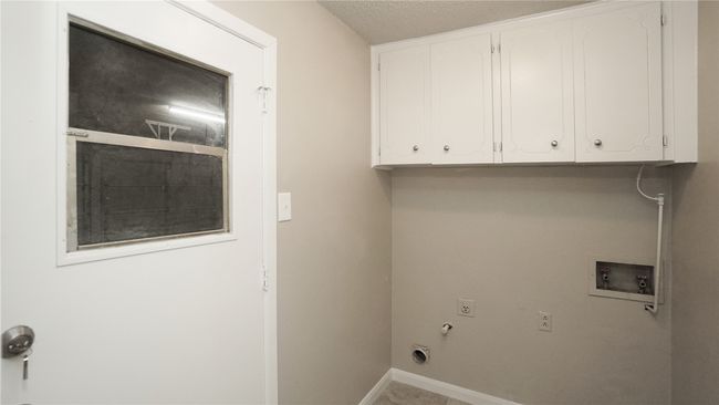 The laundry room features washer and electric dryer hookups, as well as cabinet space. It grants access to the garage | Image 21