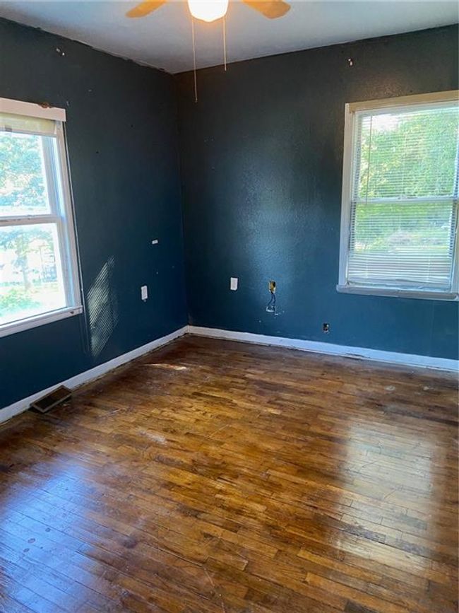 Empty room featuring baseboards, visible vents, hardwood / wood-style flooring, and a ceiling fan | Image 7