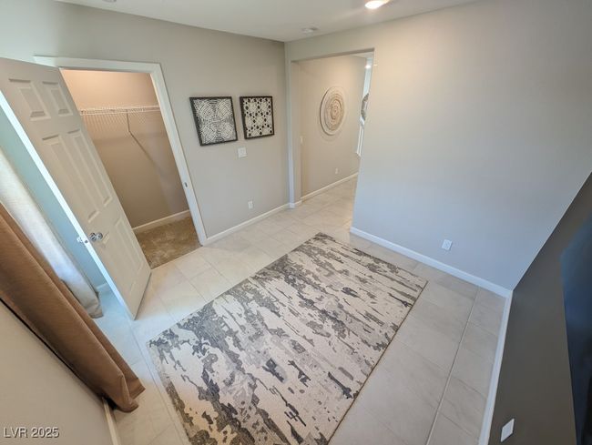 Unfurnished bedroom featuring light tile patterned floors, a walk in closet, and a closet | Image 16