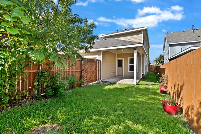 Rear view of house with a patio, a fenced backyard, and a shingled roof | Image 30
