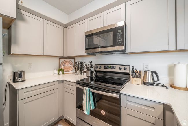 Kitchen featuring appliances with stainless steel finishes and light stone counters | Image 6
