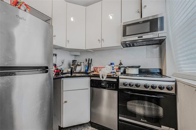 Kitchen with appliances with stainless steel finishes, white cabinets, and decorative backsplash | Image 16