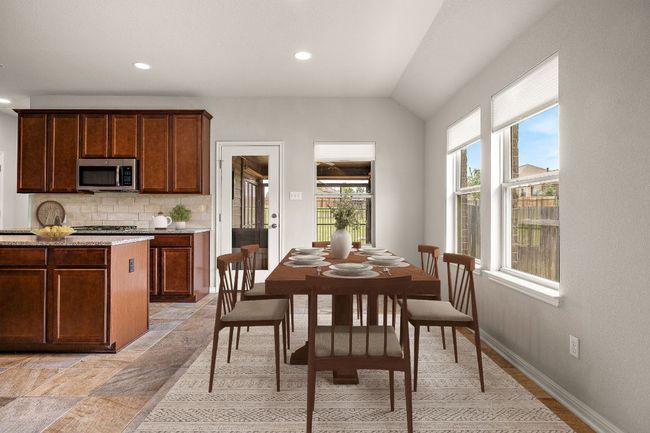 Dining area featuring stone tile floors, recessed lighting, vaulted ceiling, and baseboards | Image 8