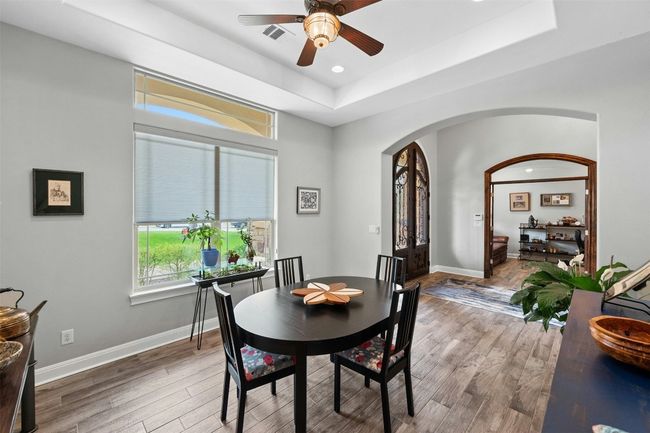 Formal dining area features a tray ceiling that gives the space a touch of elegance. | Image 12