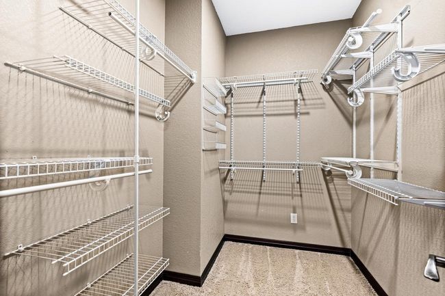 Primary walk-in closet with custom shelving to meet your wardrobe needs. | Image 16